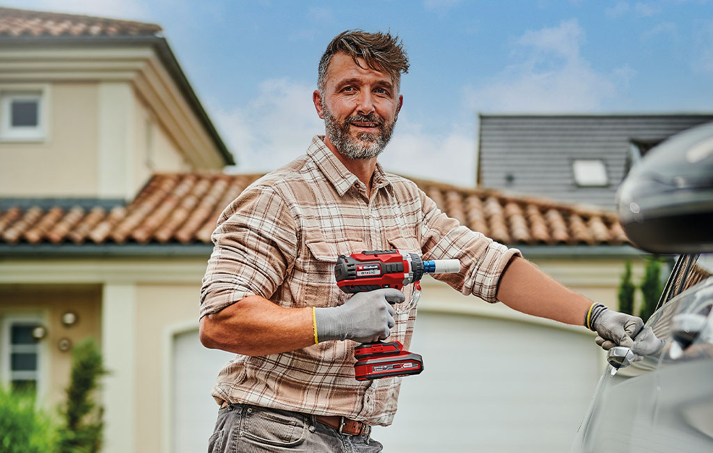 a man is holding the Einhell IMPAXXO