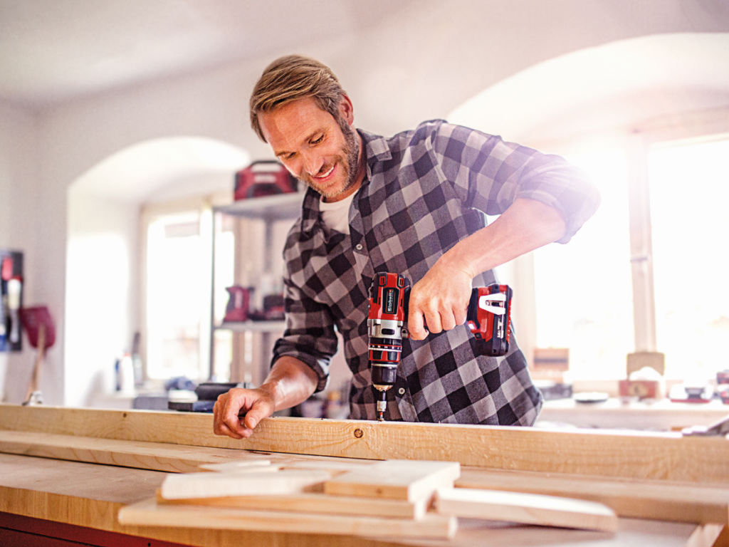 a man screws into a wooden slat