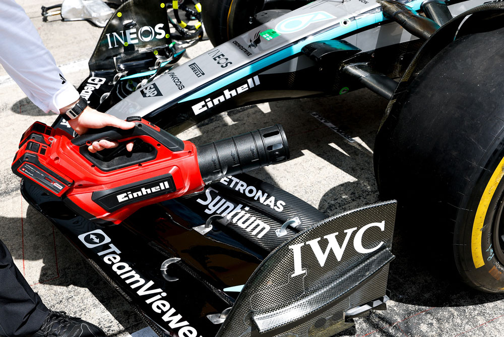 Suflanta de frunze Einhell îndreptată spre aripa frontală a unei mașini de Formula 1.