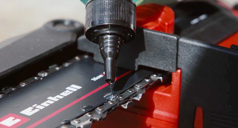 A close-up shows the chain of an Einhell chainsaw being lubricated with a precision bottle