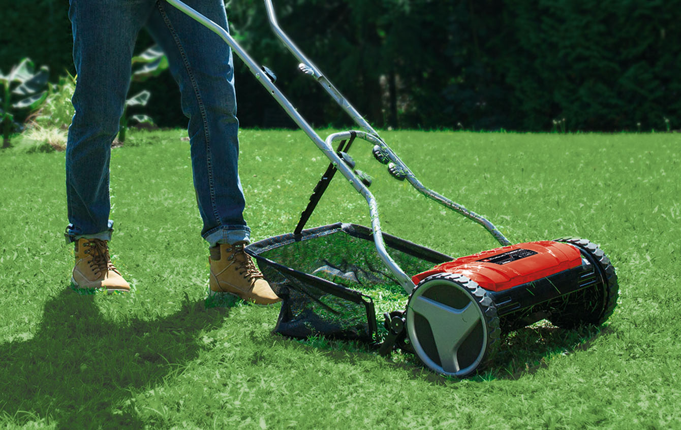 Close-up of an Einhell hand lawn mower in the garden, with focus on the grass catch bos