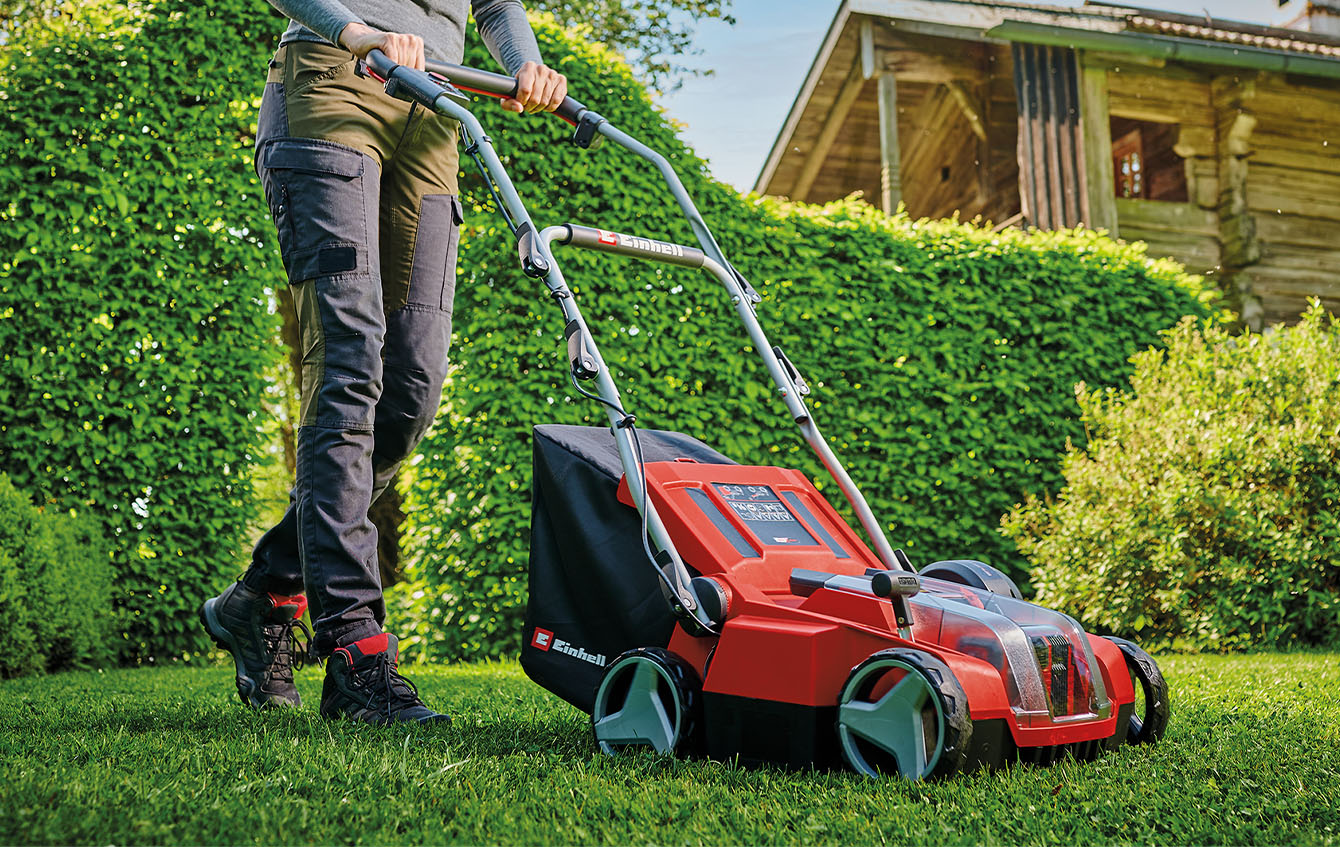 someone is mowing the lawn with a Einhell cordless lawn mower
