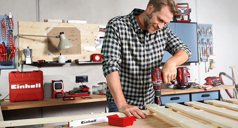 man working with a cordless screwdriver in a workshop