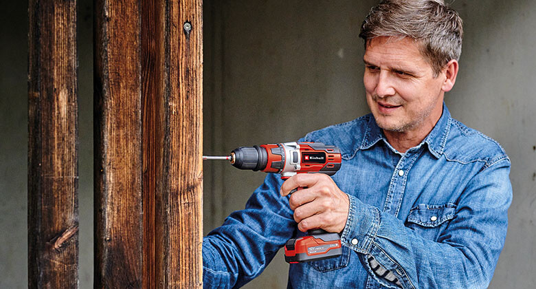 man working with a cordless screwdriver on wood