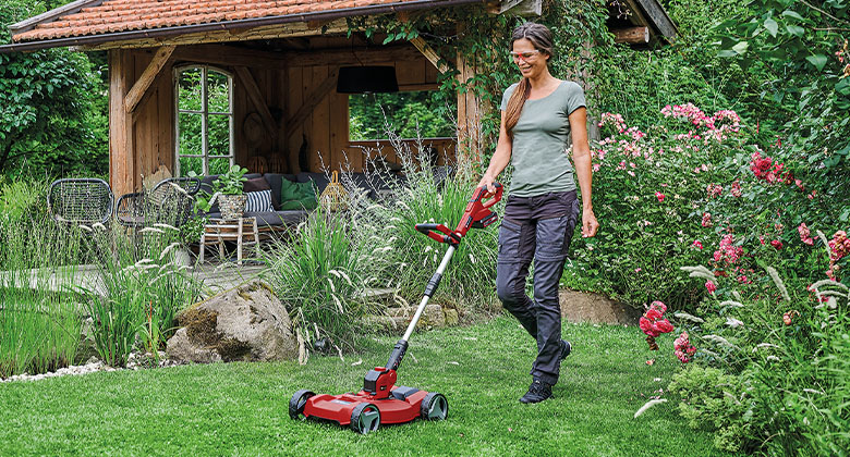 a woman using Einhell Cordless Lawn Trimmer with Trimmer Cart