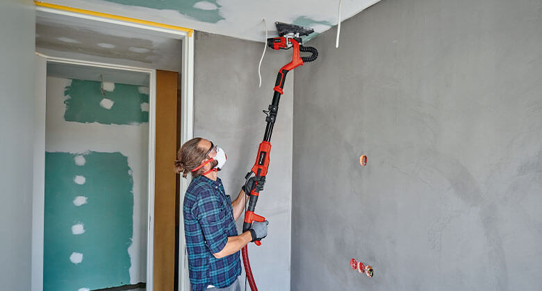 man working with a drywall polisher