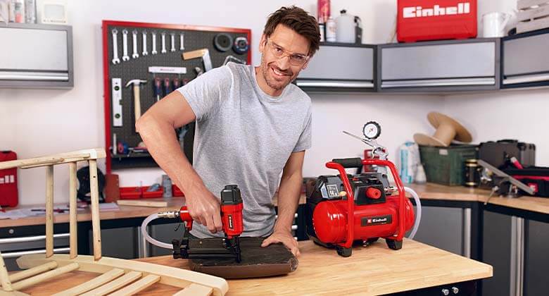 man working with an air compressor in a workshop